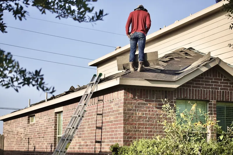 Professional roofer working on a residential roof in Maquoketa